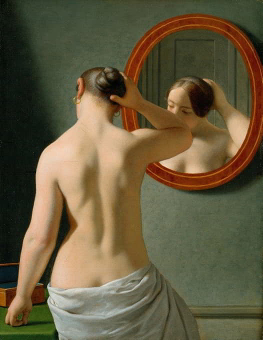 一个裸体女人对着镜子做头发