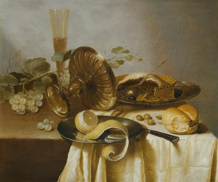 桌子上摆着一个馅饼、一个去皮的柠檬、面包、榛子、葡萄、一个玻璃杯和一个翻倒的塔萨