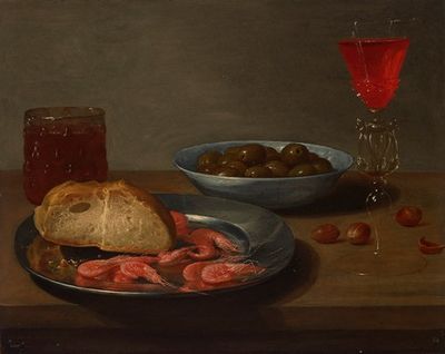 一盘大虾和一个面包卷，一碗橄榄，一个法式威尼斯，一杯啤酒和杏仁摆在桌子上